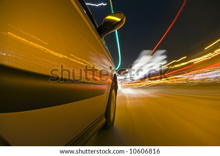 The side of a car, driving at high speed through urban streets, with the various lights passing by, reflecting in the bodywork