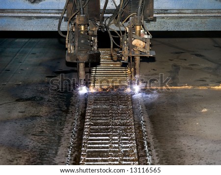 Detail of an industrial plasma cutter, cutting steel slabs into the desired width on a water cooled plasma cutting line
