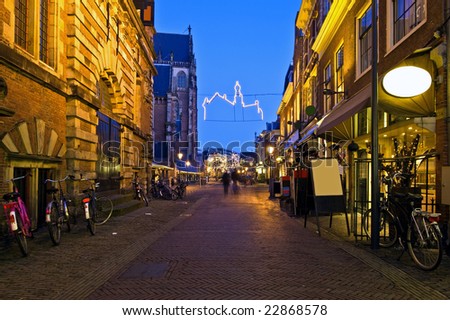 An alley with restaurants, displaying their specialties on a winter evening in Haarlem, the Netherlands