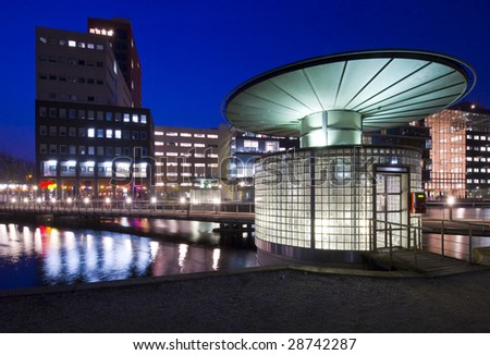 Modern urban scene with a futuristic looking entrance to an underground parking garage