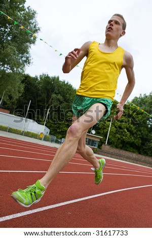 Running athlete on a middle distance race on an oval track in mid-air
