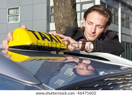 A cab driver proudly placing his taxi sign on the roof of his car