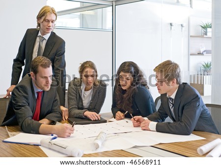 Five colleagues going over blue prints