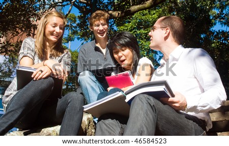 Four college students having fun on the steps of the college grounds