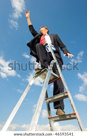 A businessman on a ladder reaching for the sky as if the limit is beyond the sky.