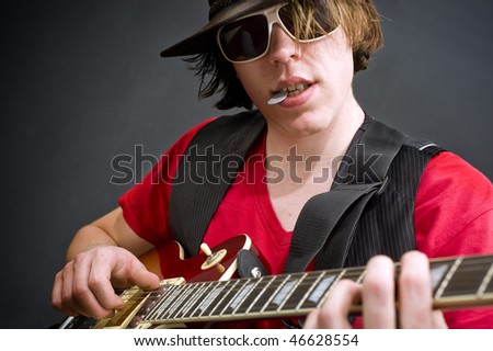 A musician wearing an old leather hat playing a guitar solo