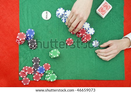 A pair of hands stacking chips on a poker table