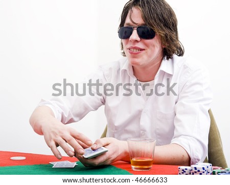 A player with big sunglasses displaying an ambiguous smile as part of his poker face