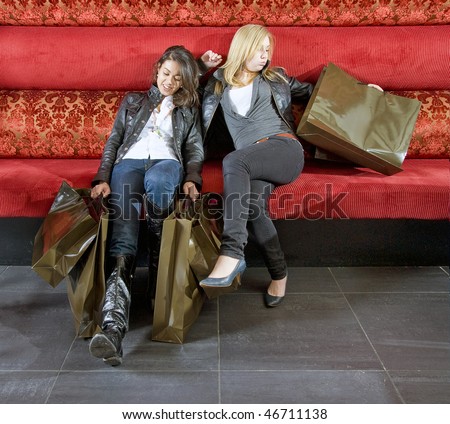 two young women taking a rest in a trendy restaurant after shopping