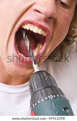 Man with his mouth wide open, drilling in his own teeth with a drill.