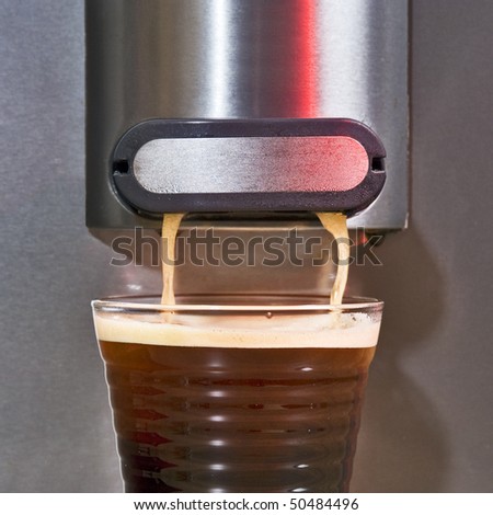 Close up of a pad coffee maker brewing a fresh cup of creamy coffee