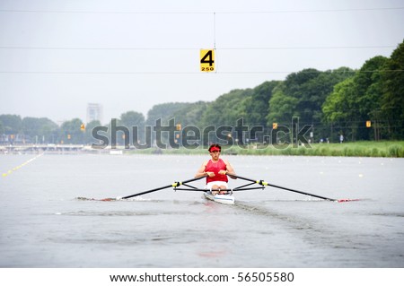 Man, rowing in a skiff during a race  at full speed