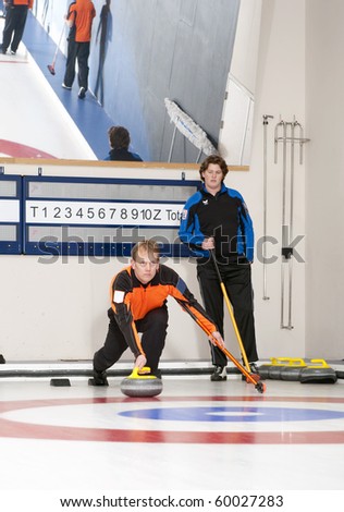Curling player delivering a stone to the house