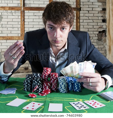 Greedy man holding a large stack of chips and a large amount of cash