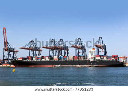 Container ship being unloaded at an industrial harbor
