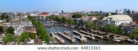 View from above on Amsterdam, the boats along the river Amstel, and the skyline, with highrise buildings, theaters, and numerous touristic landmarks