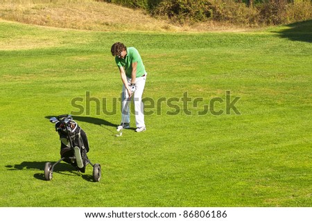 Golf player taking a swing on the fairway of a golf course
