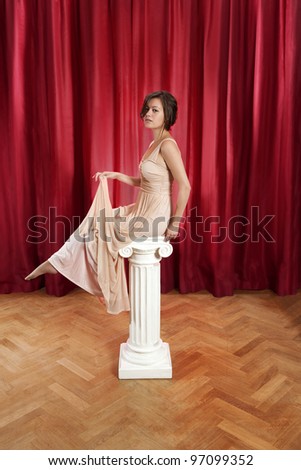 young woman, sitting on a greek - ionic - pillar in a long evening dress