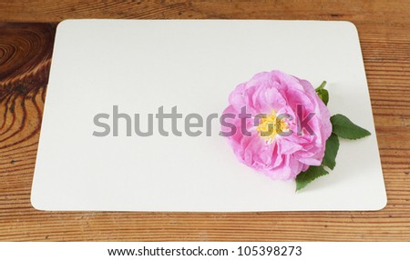 card with a blank space for text and rose on table