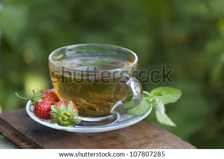 cup of green mint tea with strawberry outdoor
