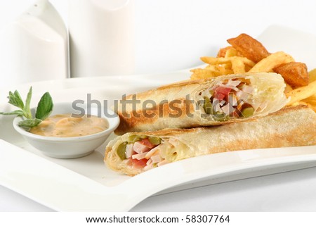 Smoked Turkey Rolled sandwich & fried potatoes, in a white plate