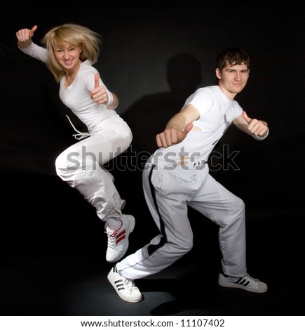 Creative shot of couple doing break-dance and showing positivity. Not isolated. Light shadows on the walls.