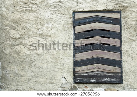 outside view on old locked jail window with a wood shutter