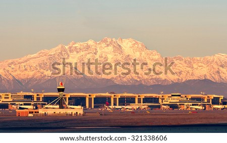 MILAN MALPENSA - DECEMBER 21, 2013: Milan Malpensa airport at sunrise, with the Alps and Monte Rosa (Pink Mount) on the background,