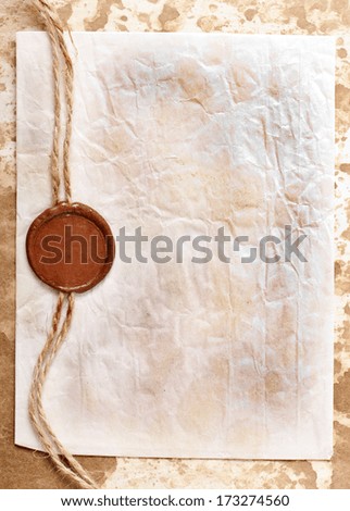 sheet of paper with a wax seal on old paper background