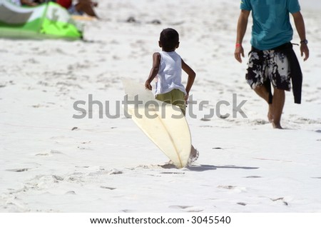 Kid bringing a broken surf board back to the surfer on a white sand beach in Brazil