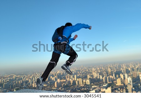 BASE jumper jumping off the Jin Mao Tower in Shanghai, China at sunrise