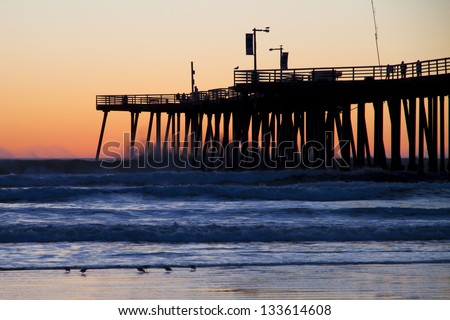 Pier at sunset with stormy waves