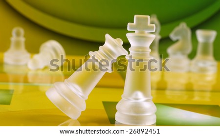 Chess coins on green and yellow background chess board