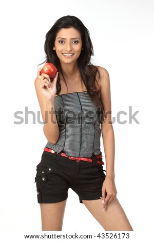 stock photo Slim girl standing in short jeans holding fresh red