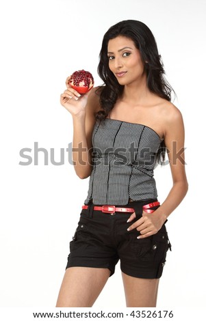 stock photo Slim girl in short jeans holding fresh red pomegranate