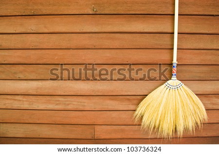 broom hanging on the wooden wall ready for cleaning work