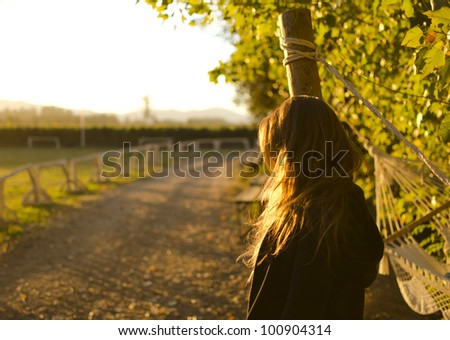 Girl is looking at the horizon with a beautiful sunlight