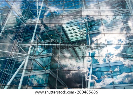 Sky and clouds reflected in the windows of an ecological and sustainable building.