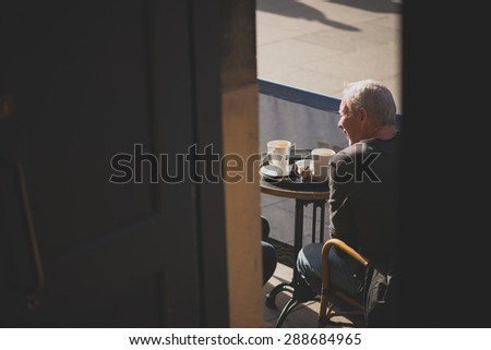 EDINBURGH, SCOTLAND / UNITED KINGDOM - MAY 24 2015 - Unidentified man having a cup of coffee out in the street.