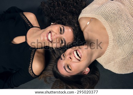 Two sisters lying on the ground laughing