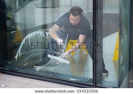 SANTIAGO, REGION METROPOLITANA / CHILE - AUGUST 05 2015 - Unidentified man cleaning windows in a corporate building.
