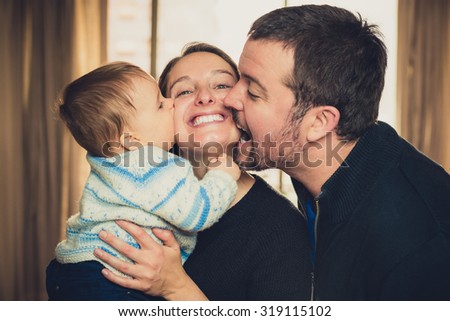 Beautiful young family. Father and son kissing the mother
