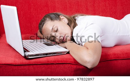 Woman falls asleep after a hard work afternoon. She sleeps over her laptop