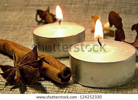 Candle, cinnamon sticks and anise stars
