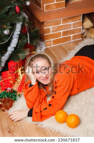 Smiling woman in orange sweater laying on bear rug