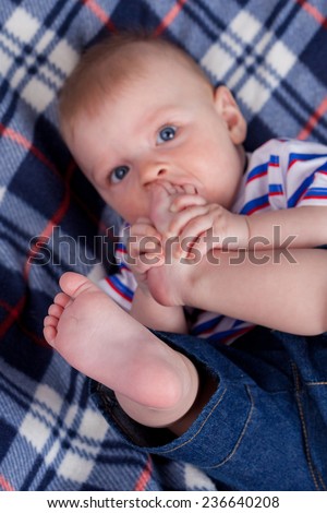 Little boy with his feet in mouth