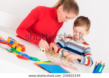 Mother and son playing  in  board game at white desk