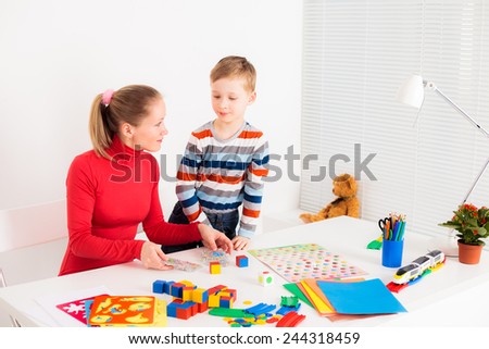 preschooler child playing in  board game with his mom