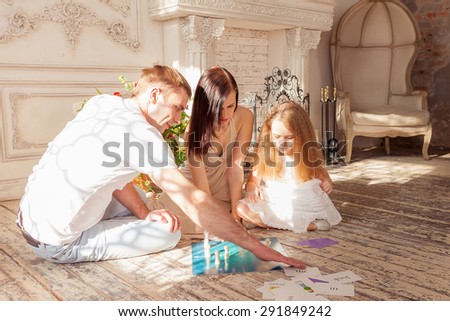 Happy family playing board game  in their living room
