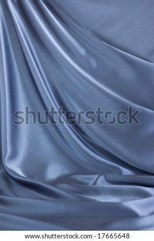 Blue silk background; soft satin fabric drapery as background; abstract background luxury curtain; wavy folds of silk texture velvet material; empty place to put your object